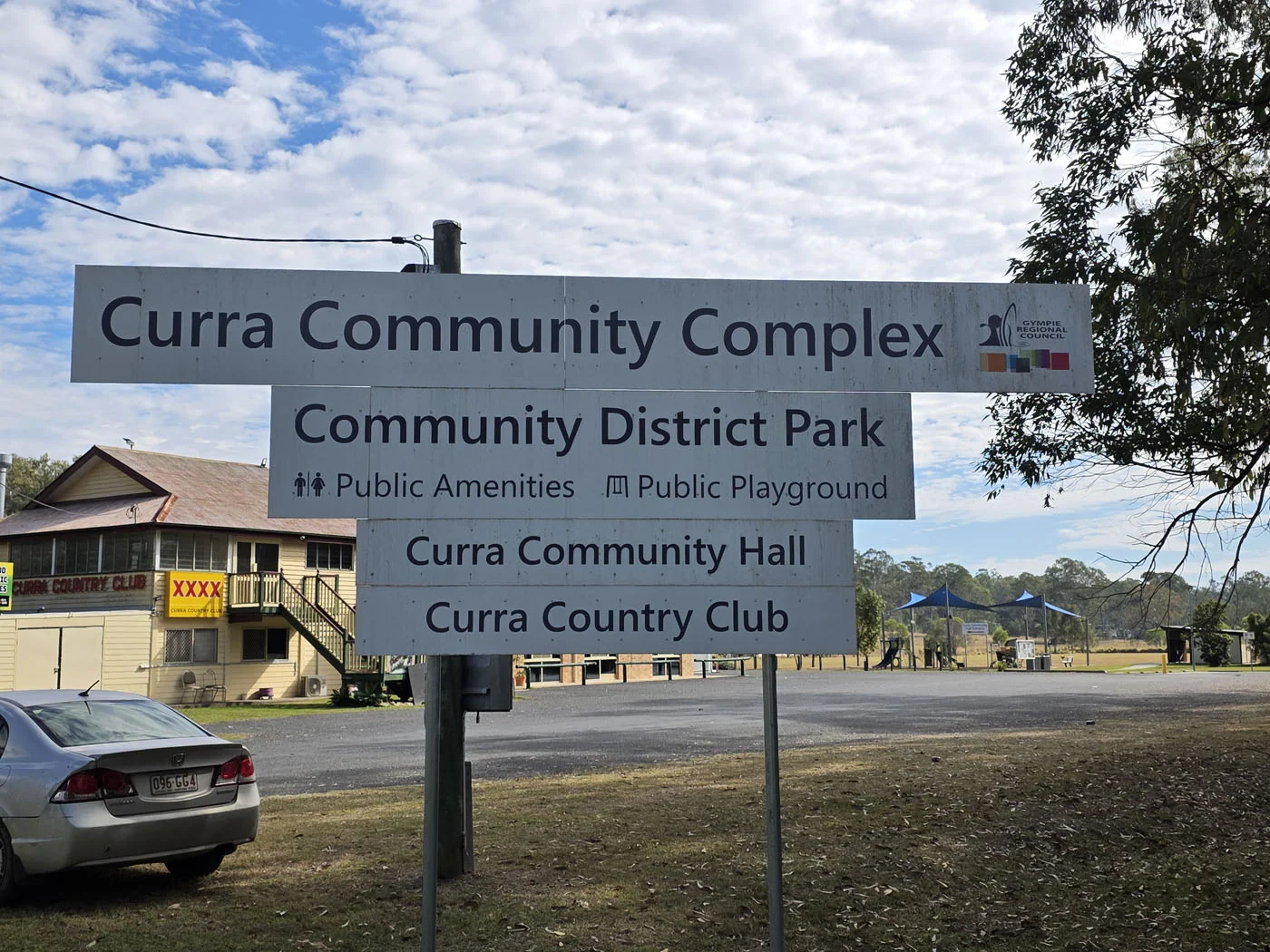 Curra Community Complex sign listing the Community District Park, Community Hall and Curra Country Club