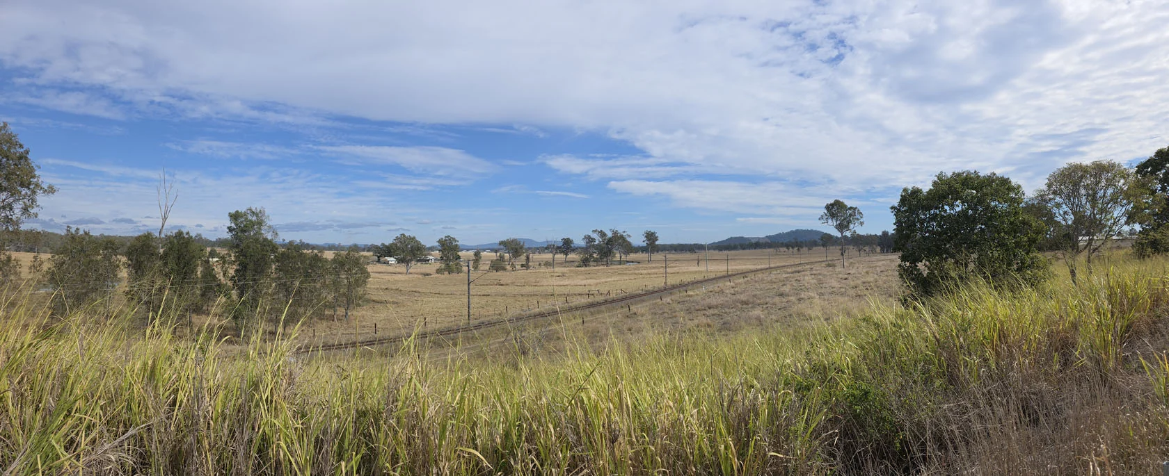 Wide rural view across Curra showing open country and homes separated by distance