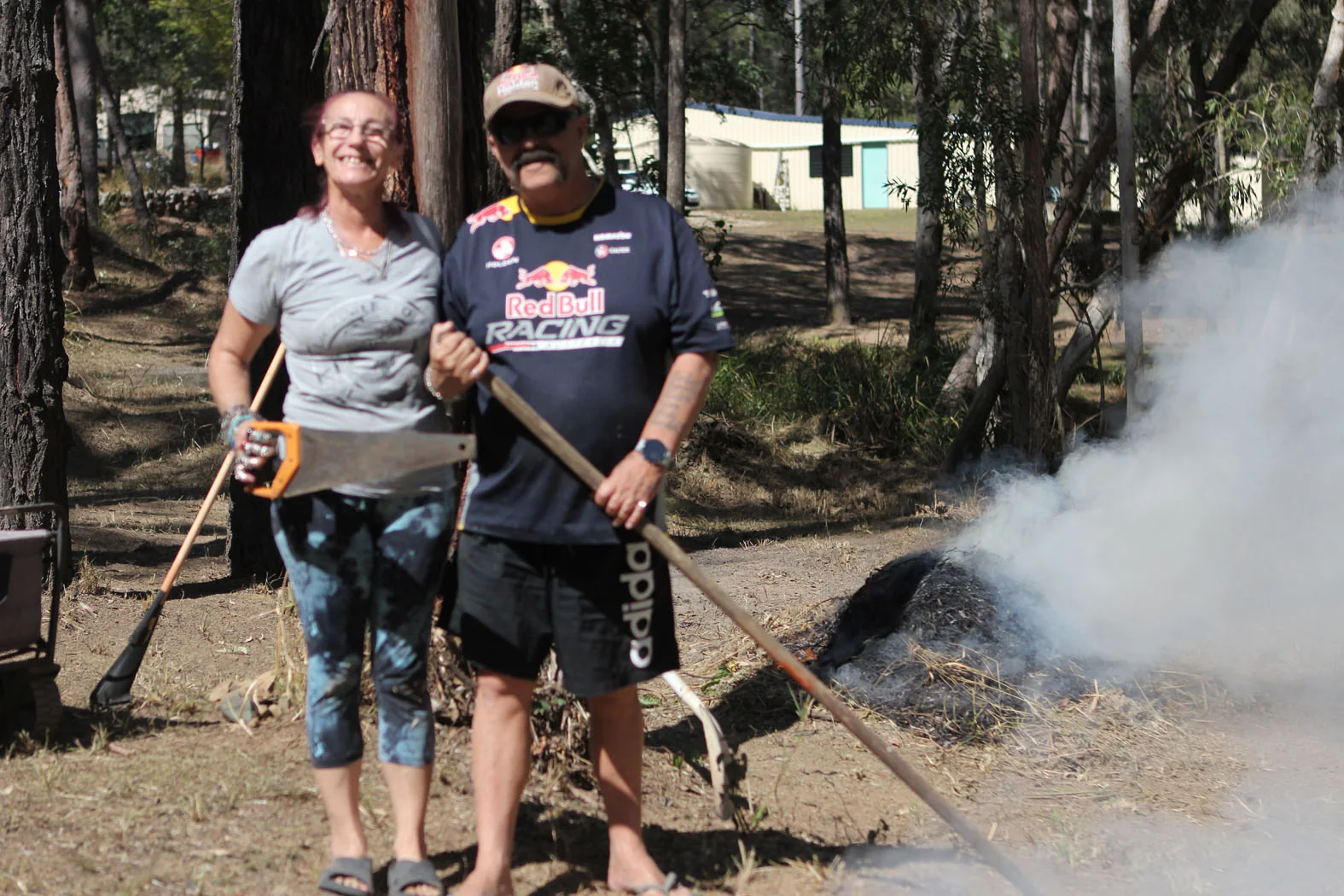 Dell and her husband beside a controlled vegetation burn in Glenwood